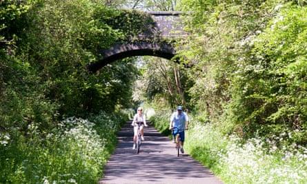 A couple cycling on the Bristol and Bath Railway Path in spring.