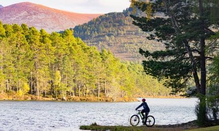 A teenager cycles to the edge of Loch an Eilein.