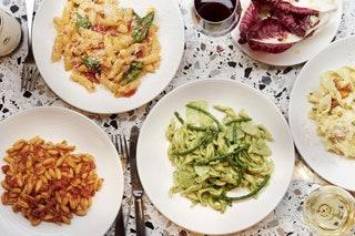 Pasta made inhouse that day is served with simple ingredients in a simple setting canteenstyle terrazzopatterned tables...